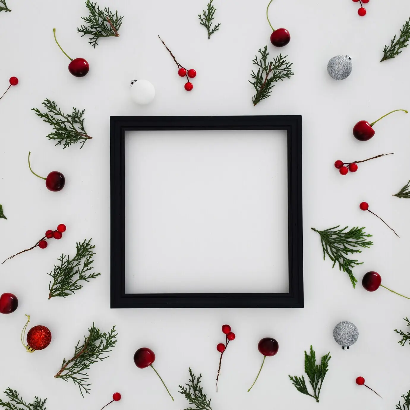 Schwarzer Rahmen mit Mustern aus Kiefernnadeln und dekorativen Weihnachtskugeln.