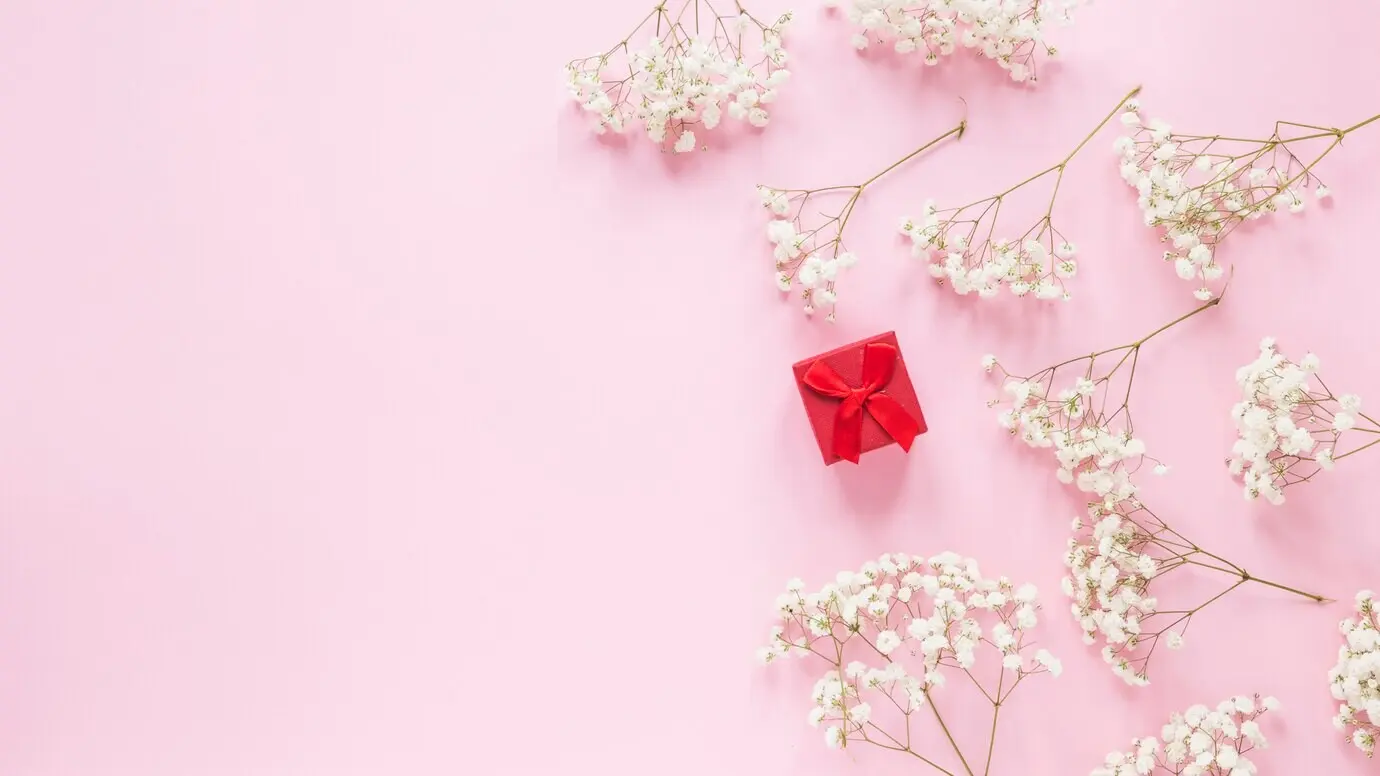 Kleine Geschenkschachtel mit Blumenzweigen auf einem Tisch